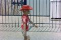Photograph: [Young boy wearing a red cowboy hat and walking]