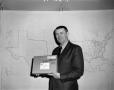 Photograph: [Lawton Williams holding a package]