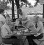 Photograph: [Men sitting at a picnic table]