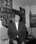 Photograph: [Ron Spain in front of football posters]