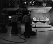 Photograph: [Photograph of newsmen and silhouettes of floor crew]