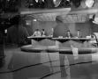 Photograph: [Photograph of newsmen with floor crew silhouette]