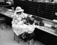 Photograph: [A women and a child at a store, 6]
