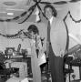 Photograph: [Photograph of individuals in a room decorated with streamers]