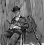 Photograph: [Jim Baker holding a gun and cards]