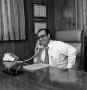 Photograph: [Photograph of Ron Godbey seated at desk]