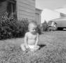 Photograph: [Photograph of a baby sitting on a lawn]