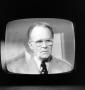 Photograph: [A man on a television screen]