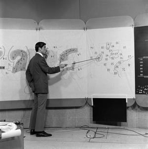 Primary view of object titled '[Ken McCool with a weather map]'.