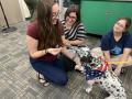 Primary view of [Abigail Mueller and Maren Garcia with therapy dog]