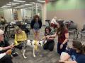 Photograph: [Maren Garcia and Abigail Mueller with therapy dog]