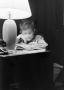 Photograph: [Photograph of a little boy reading at a desk]
