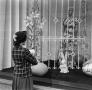Photograph: [Photograph of a woman looking at an Easter window display]