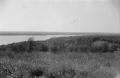 Photograph: [Photograph of a grassy field by a body of water]
