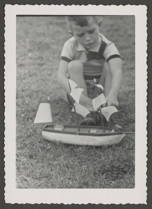 Primary view of [Photograph of Tim Williams playing with a toy boat, 7]