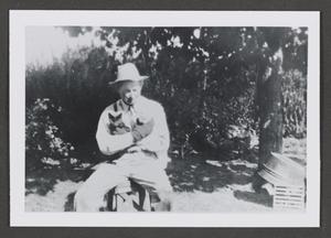 Primary view of object titled '[Photograph of a man holding two cats]'.