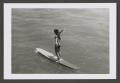 Photograph: [Photograph of a woman standing on a surfboard, 2]