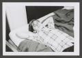 Photograph: [Photograph of a boy lying on a bed]