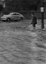 Photograph: [Man standing in a flooded street]