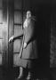 Photograph: [Mary Liddell in a large coat]
