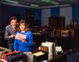 Photograph: [Photograph of Jane McGarry and a man posing at a desk]