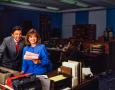 Photograph: [Photograph of Jane McGarry and a man at a desk]