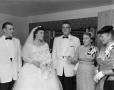 Photograph: [Bride and groom with three wedding guests]