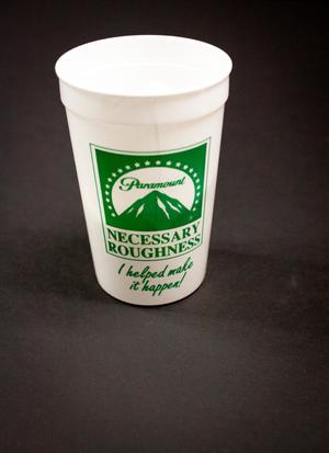 A white plastic cup with the Paramount symbol on it in green, the words Necessary Roughness under it. Under that are the words I helped make it happen in green.