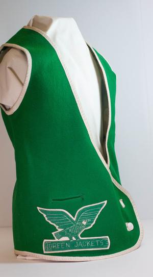 A green vest rimmed with white. On the right side of it is a patch with an eagle and the words Green Jackets on it.