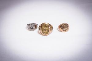 3 gold and silver college class rings.