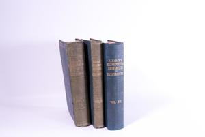 The spine of three books can be seen side by side. The books are a dark blue. The two on the farthest left are more worn out than the one furthest on the right.