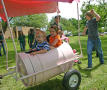 Photograph: [Children riding in barrel cart]