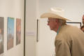 Photograph: [Exhibit attendee looking at photographs]