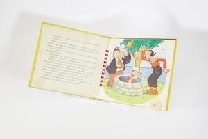 La página de la derecha es una ilustración de un hombre y una mujer en los dibujos animados de Popeye. El propio Popeye está dentro de un pozo con una pipa en la boca. Detrás de ellos hay un árbol y agua. La página de la izquierda contiene un texto.