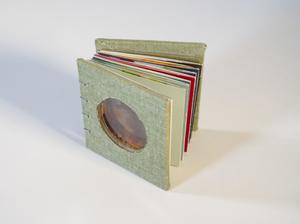 A small book with several sections, the front of it has a clear circle.
