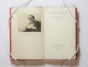 A book open, the page on the left containing a photograph of a man holding a book and pen. The page on the right is the title page.