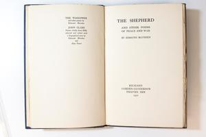 A book open to two pages, the one on the left containing a small amount of text at the top. The page on the right containing the title page.