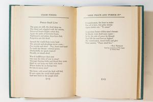 An open book, the page on the left containing a poem titled Peace Shall Live. The page on the right a continuation of the poem.