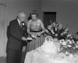 Photograph: [Photograph of two wedding guests getting cake]