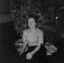 Photograph: [Photograph of a woman sitting in front of a Christmas tree]