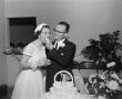 Photograph: [Photograph of a groom feeding cake to his bride]