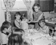 Photograph: [Photograph of Irene and her grandchildren gathered around a dining t…
