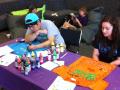 Photograph: [Two making shirts at tables from Clothesline Project]