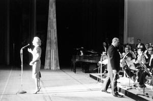 Primary view of object titled '[Alice Faye standing onstage with band]'.