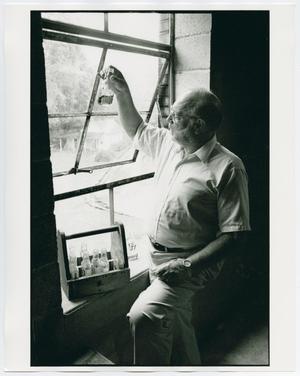 Primary view of object titled '[Frank Bobo observing distillery liquid]'.