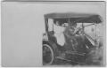 Photograph: [A man and two women in an automobile]