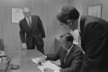 Photograph: [John DeLorean, Ed Cole and another man in an office]