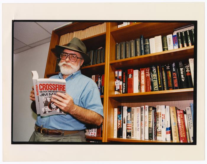 Primary view of object titled '[Portrait of Jim Marrs with his book]'.