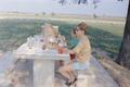 Photograph: [Doris and Pam eating at a picnic table]