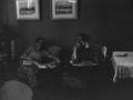 Photograph: [Charles and Johns sitting in sofa chairs]